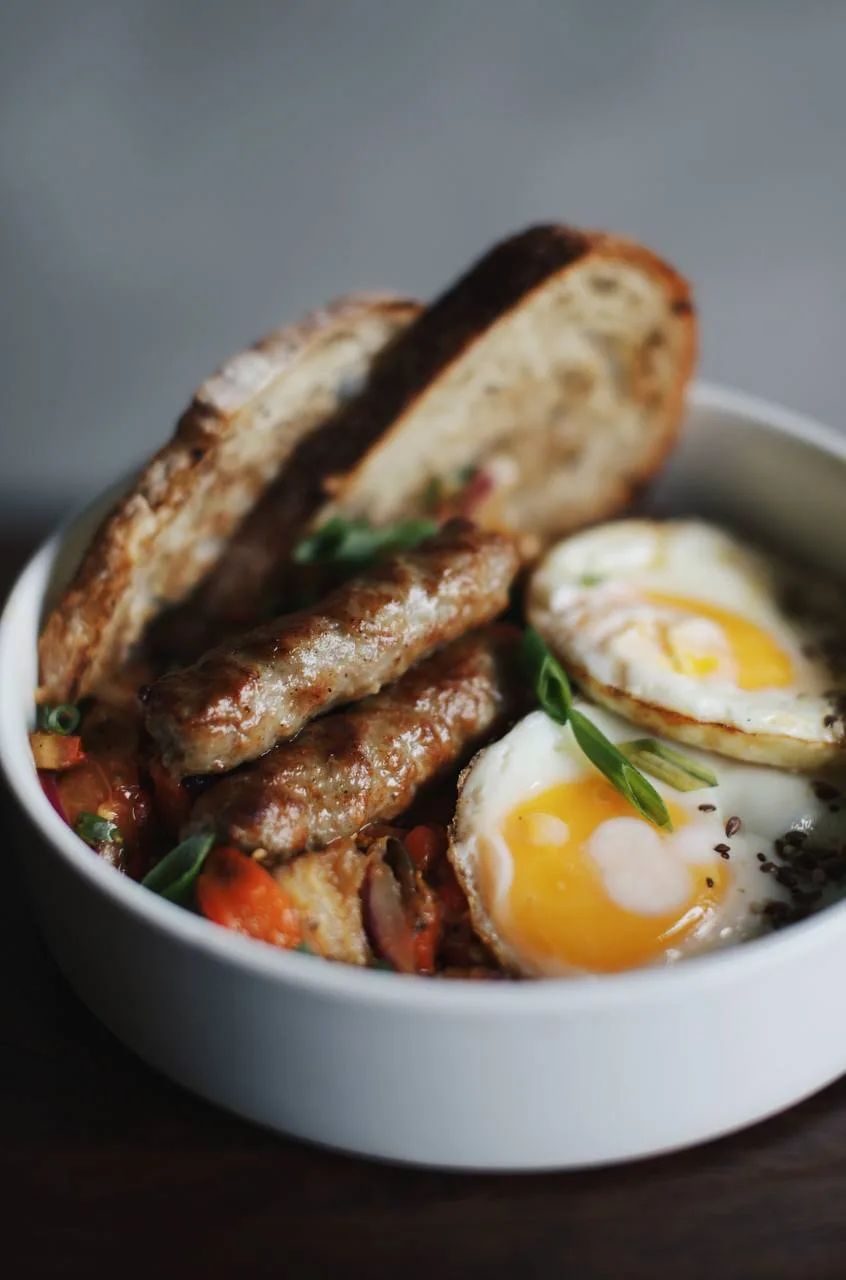 Leto Style Eggs Bowl con huevos fritos, salchicha artesanal y tostadas de masa madre
