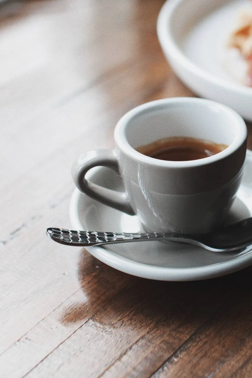 Espresso en taza blanca sobre una mesa de madera