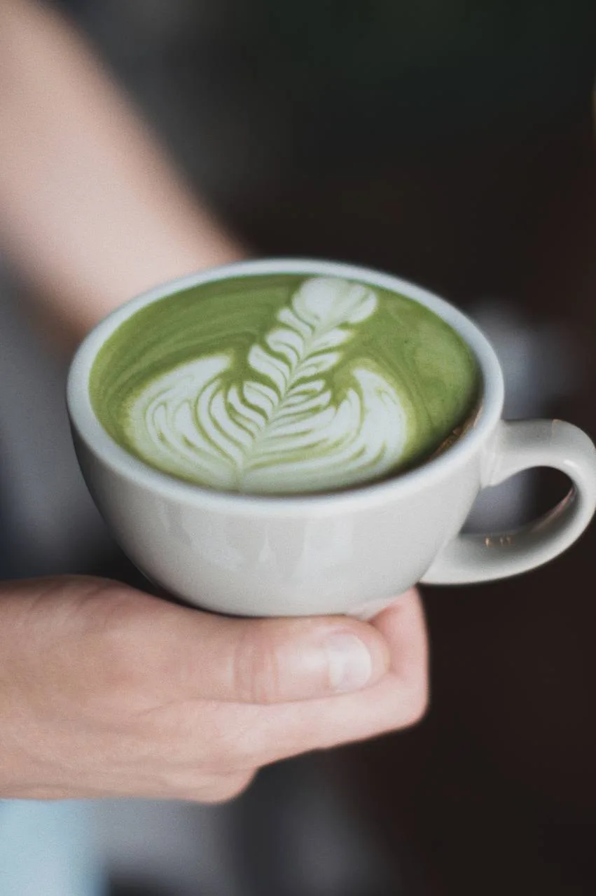 Matcha latte verde con arte en forma de hoja