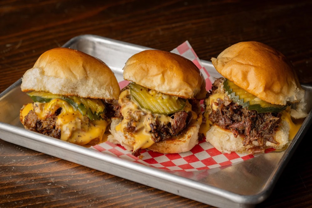 Tres BBQ sliders con barbacoa, queso derretido y pickles en charola