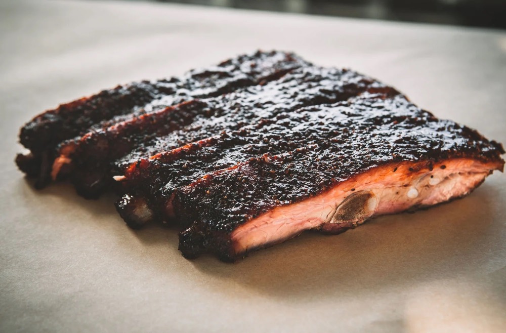 Costillas de cerdo St. Louis ahumadas con corteza oscura sobre papel