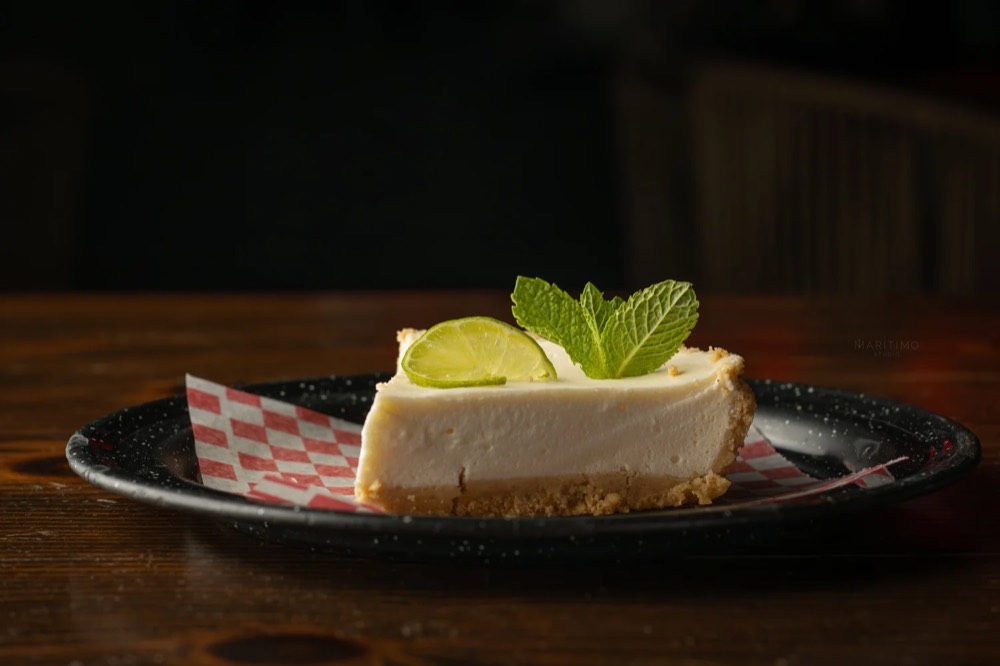 Rebanada de key lime pie con rodaja de limón y menta