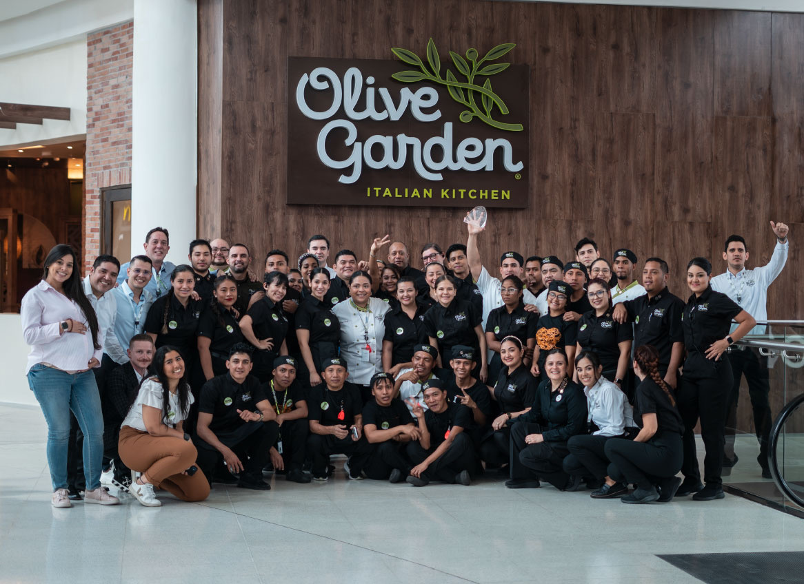 Equipo de Olive Garden Panamá reunido frente al letrero del restaurante
