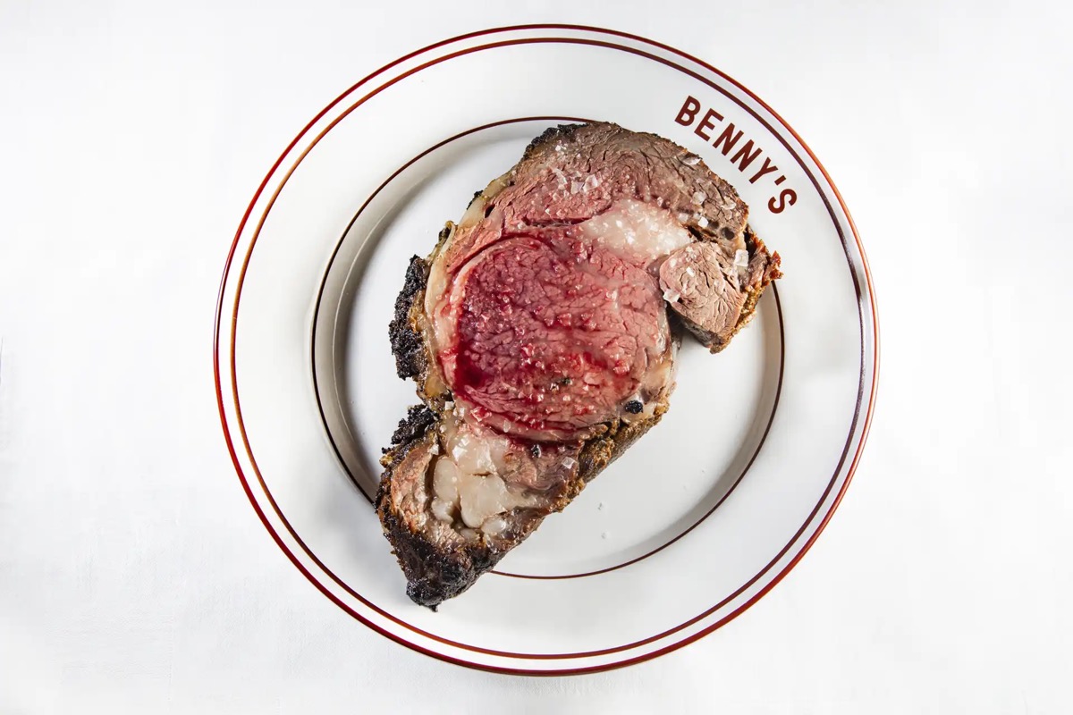 Corte de prime rib en un plato blanco con el logo de Benny's