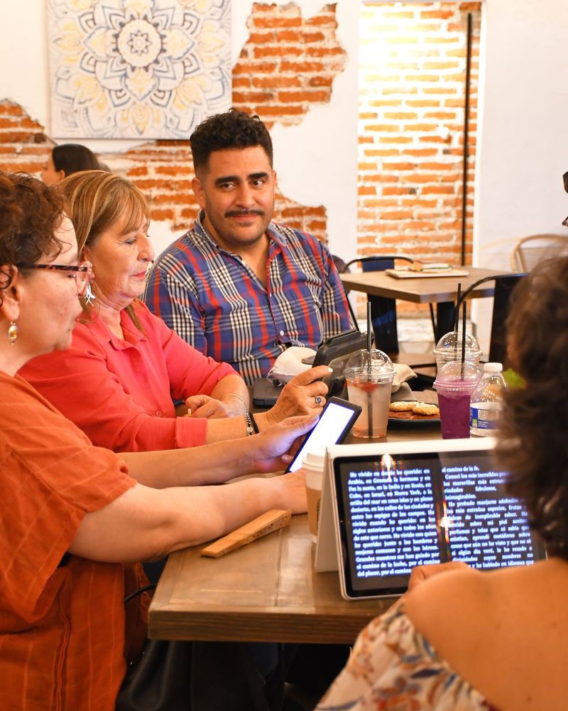 Grupo conversando alrededor de una mesa durante el club de lectura en Boho Cafe