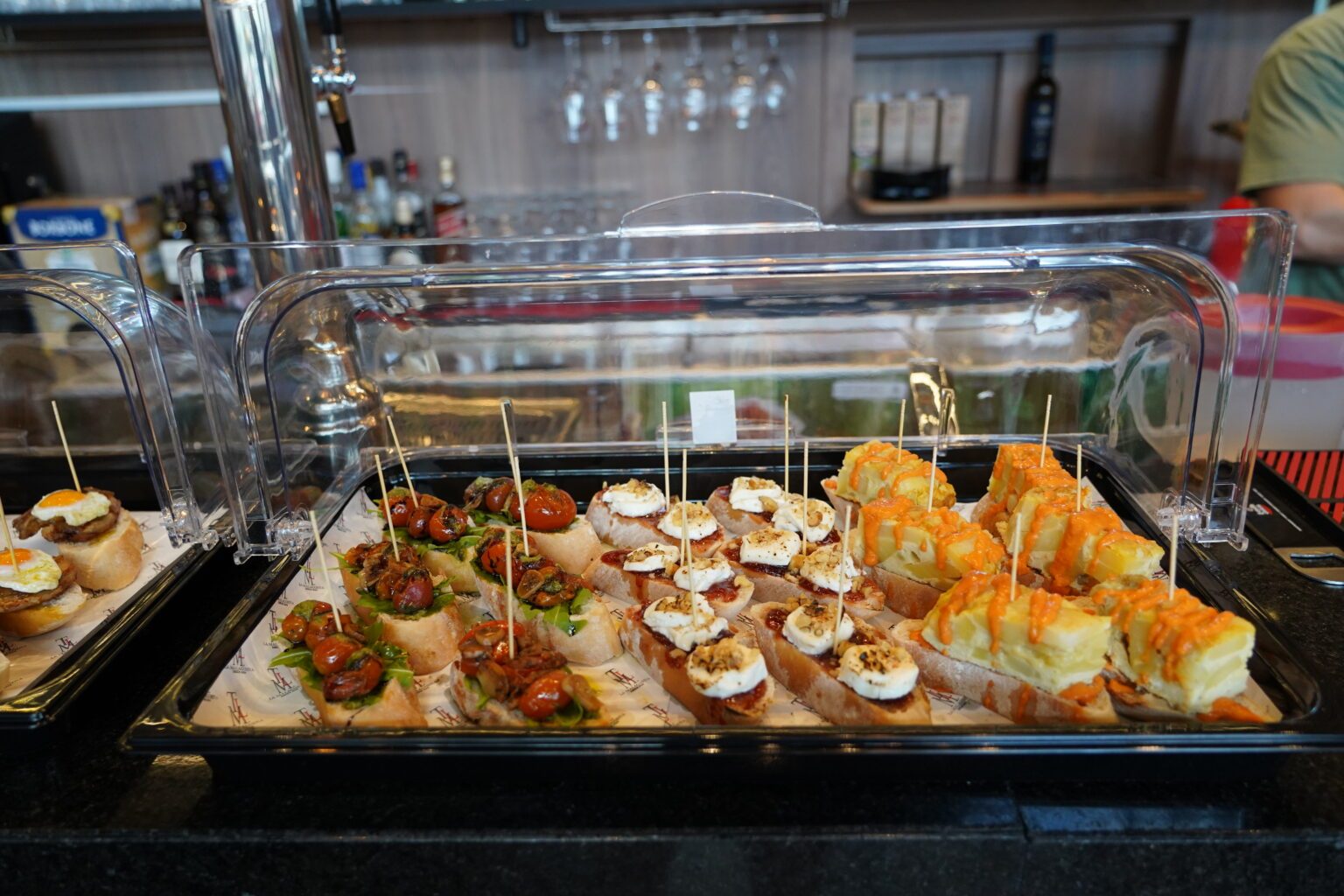 Barra de La Malagueña con una bandeja de pinchos y montaditos variados listos para servir